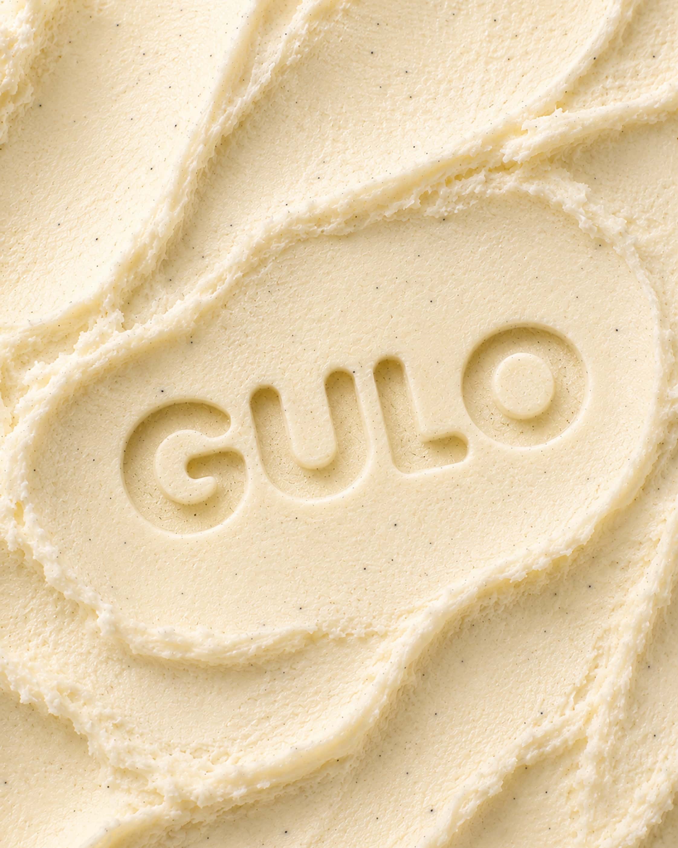 Textura cremosa de sorvete de baunilha com marca Gulo em baixo relevo